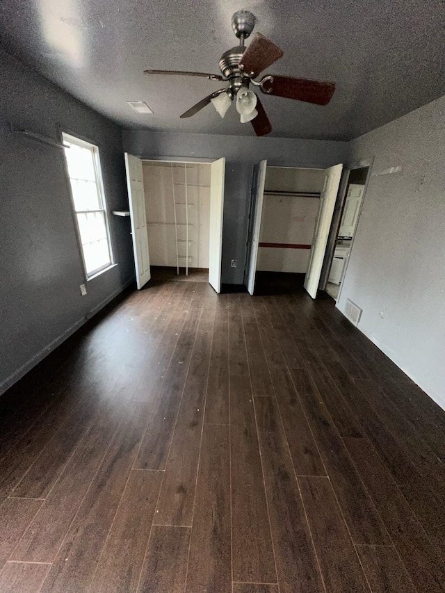 unfurnished bedroom featuring a textured ceiling, ceiling fan, and dark hardwood / wood-style floors