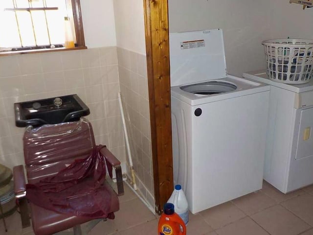 washroom featuring washer / dryer, laundry area, tile walls, and light tile patterned floors