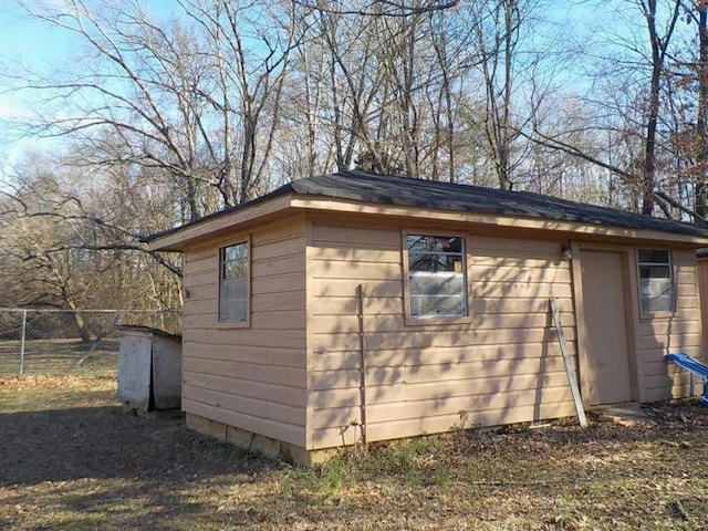 view of outdoor structure featuring fence and an outbuilding