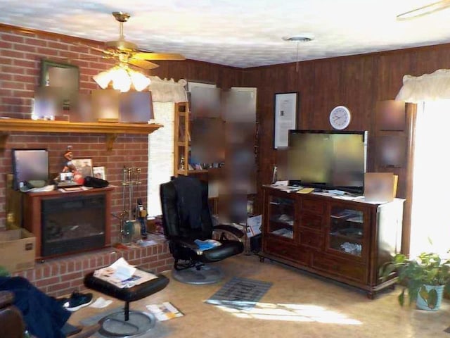 living room with a fireplace, a ceiling fan, and wooden walls