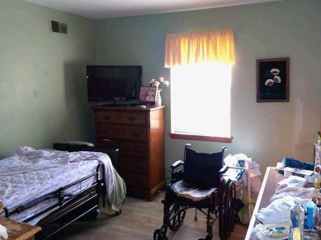 bedroom with light wood finished floors and visible vents