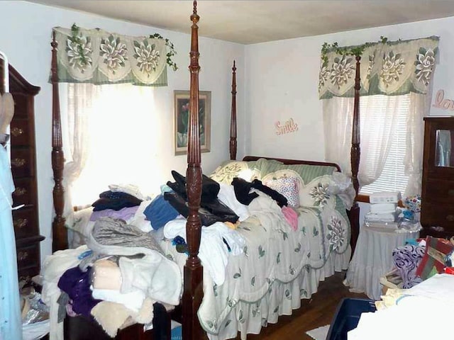 bedroom with dark wood-type flooring and multiple windows