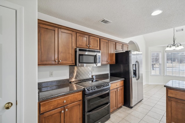 kitchen featuring a chandelier, appliances with stainless steel finishes, a textured ceiling, and light tile patterned flooring