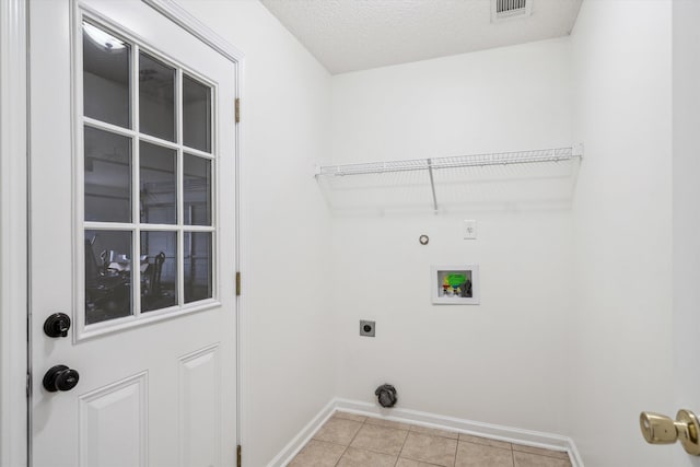 washroom featuring washer hookup, electric dryer hookup, gas dryer hookup, a textured ceiling, and light tile patterned floors