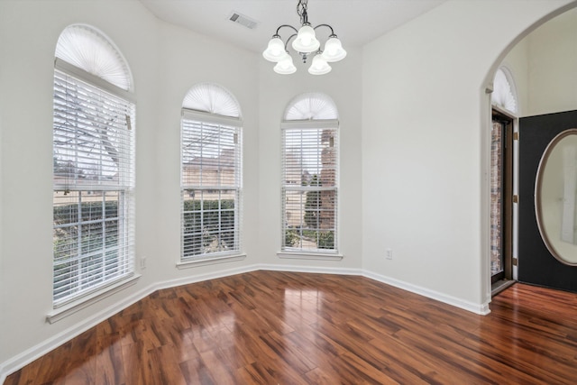 unfurnished dining area featuring dark hardwood / wood-style flooring and a chandelier