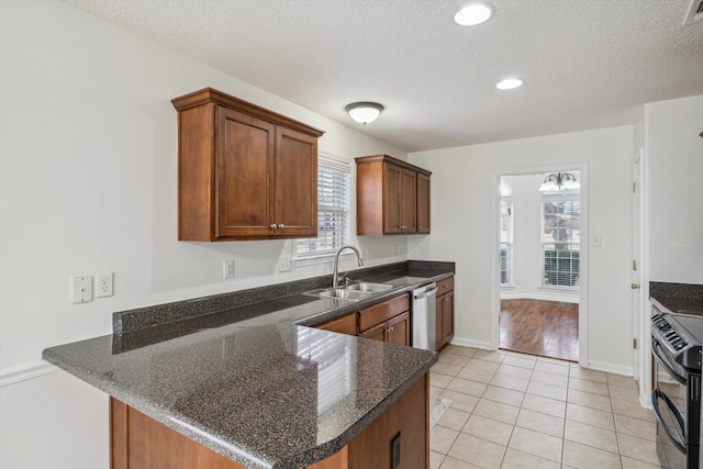 kitchen with kitchen peninsula, appliances with stainless steel finishes, and a textured ceiling