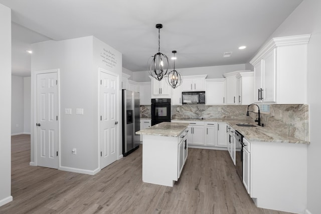 kitchen featuring white cabinetry, sink, pendant lighting, a kitchen island, and black appliances