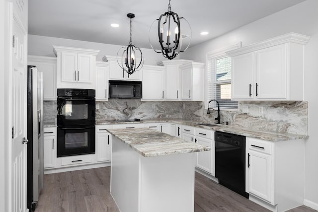 kitchen featuring black appliances, a kitchen island, white cabinetry, and sink