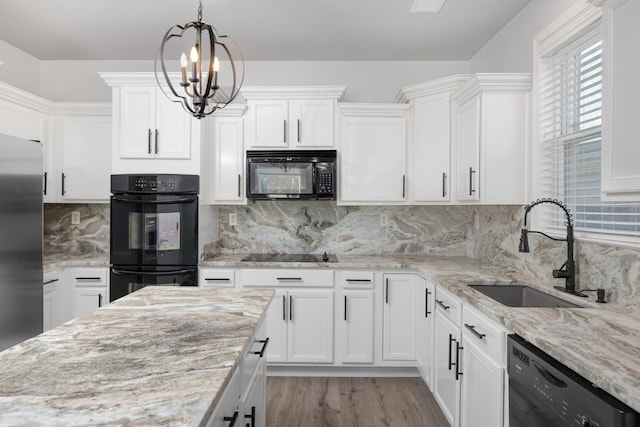 kitchen featuring backsplash, sink, black appliances, an inviting chandelier, and white cabinets