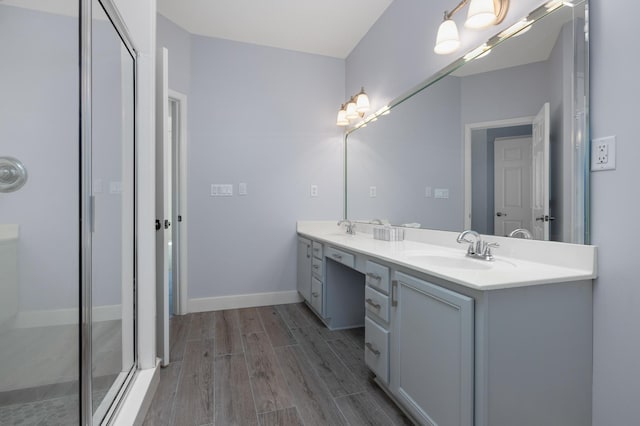 bathroom featuring vanity, hardwood / wood-style flooring, and a shower with door