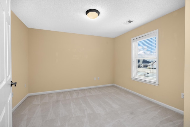 carpeted empty room with a textured ceiling