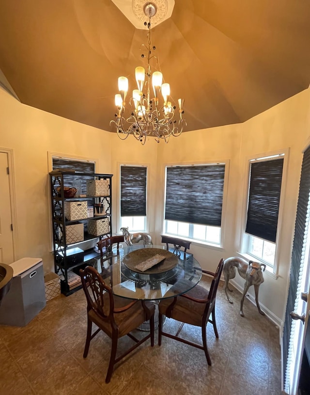 dining space featuring vaulted ceiling and an inviting chandelier