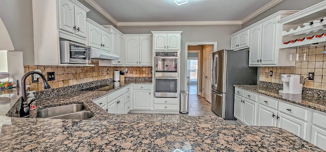 kitchen featuring white cabinets, stainless steel appliances, dark stone counters, and sink