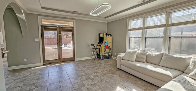 living room with french doors, a tray ceiling, light tile patterned floors, and ornamental molding