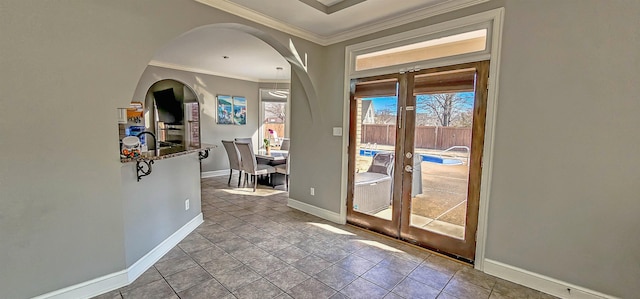 entryway with french doors, light tile patterned floors, and crown molding