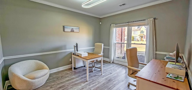 home office with light hardwood / wood-style flooring and ornamental molding