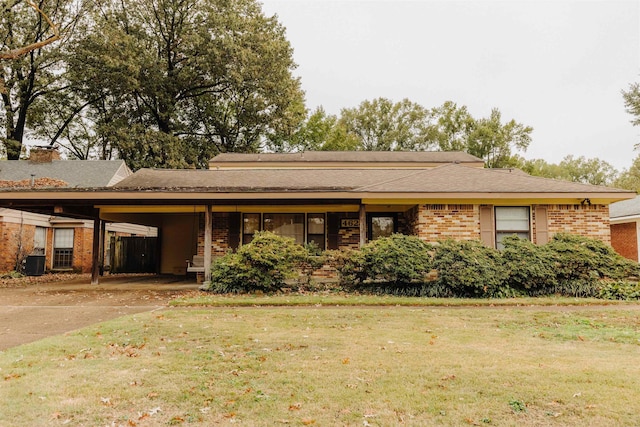 ranch-style house with a carport, central AC unit, and a front yard