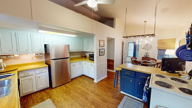 kitchen with ceiling fan, pendant lighting, light hardwood / wood-style flooring, white cabinetry, and stainless steel refrigerator