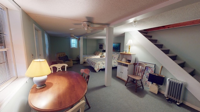 bedroom featuring radiator, ceiling fan, carpet, and a textured ceiling