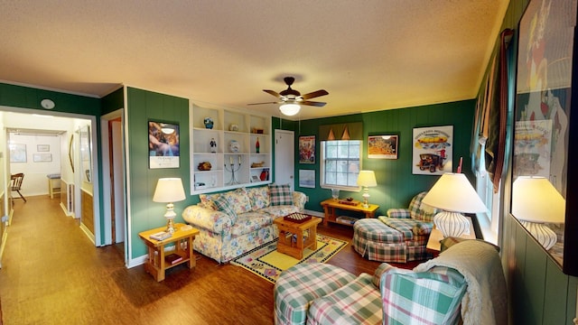 living room featuring ceiling fan, built in features, wood-type flooring, and a textured ceiling