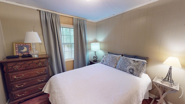 bedroom with dark hardwood / wood-style flooring and wood walls