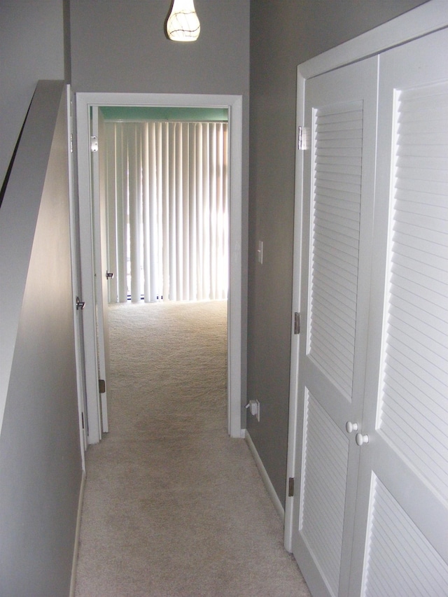 hallway featuring light colored carpet