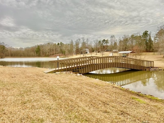 dock area with a lawn and a water view