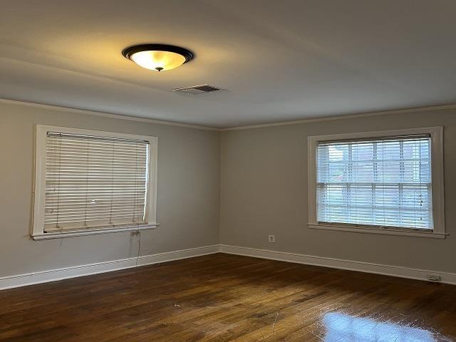 spare room featuring dark hardwood / wood-style floors and ornamental molding