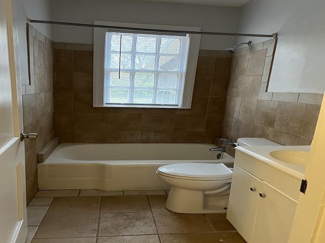 full bathroom with tile patterned flooring, vanity, toilet, and tiled shower / bath combo