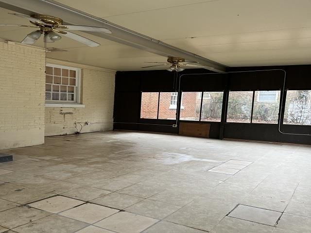 unfurnished sunroom featuring beam ceiling