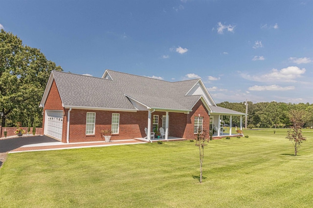 view of front of house featuring covered porch, a garage, and a front lawn