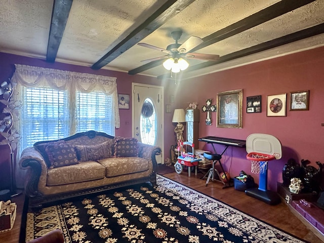 living room with ornamental molding, a textured ceiling, ceiling fan, beam ceiling, and hardwood / wood-style flooring