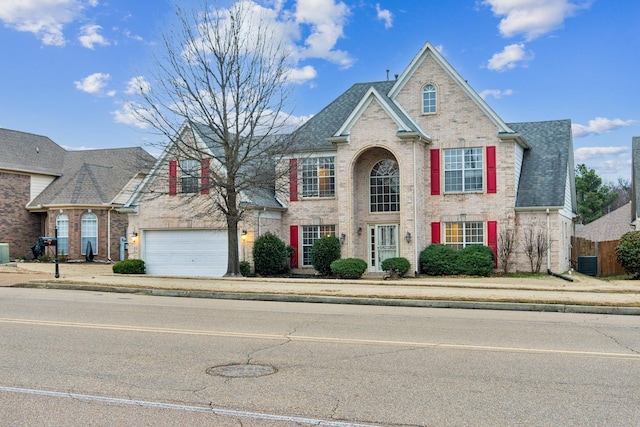 view of front of property featuring central AC unit and a garage