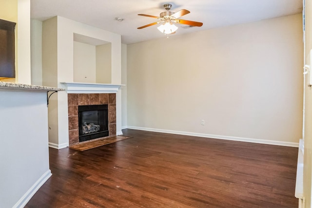 unfurnished living room with ceiling fan, a fireplace, and dark hardwood / wood-style floors