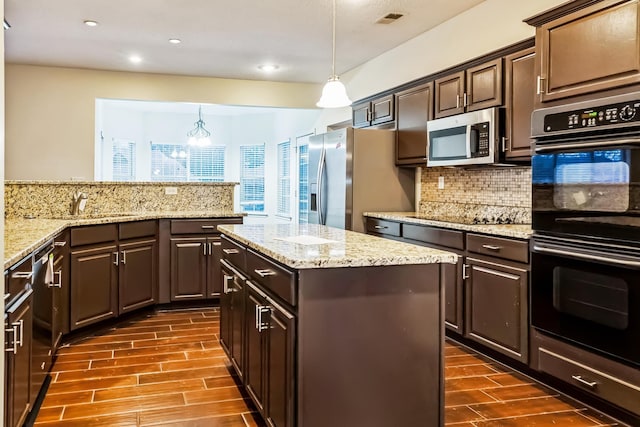 kitchen with black appliances, pendant lighting, dark brown cabinetry, and sink