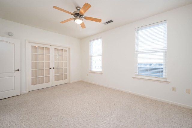 unfurnished room with ceiling fan, carpet, a healthy amount of sunlight, and french doors