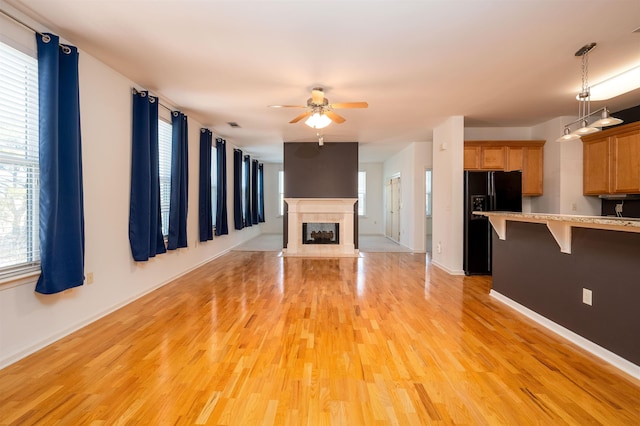 unfurnished living room with ceiling fan and light hardwood / wood-style floors