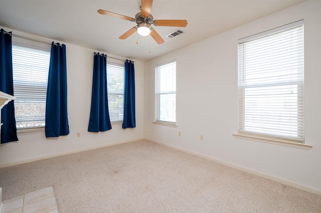 spare room with ceiling fan and light carpet