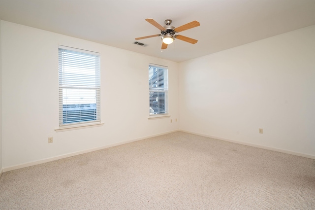 empty room featuring ceiling fan and carpet