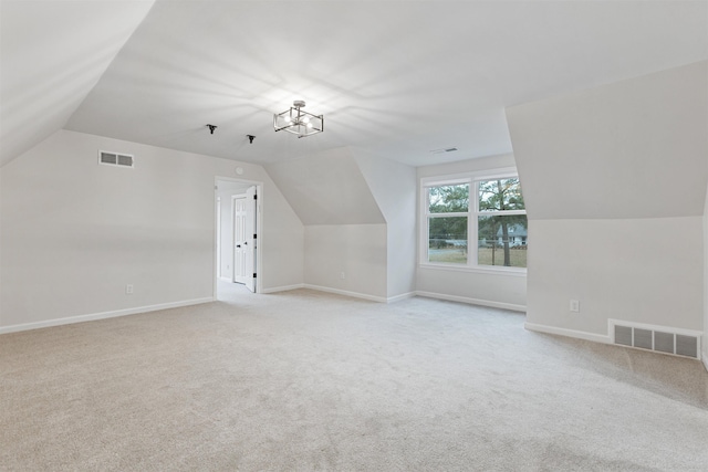 additional living space with light carpet and vaulted ceiling