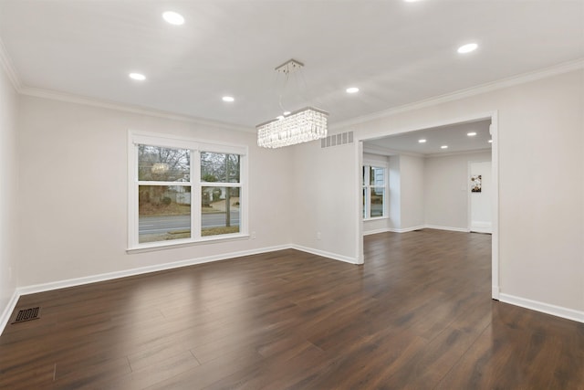 empty room featuring dark hardwood / wood-style flooring, an inviting chandelier, and ornamental molding