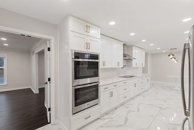 kitchen with white cabinetry, light stone countertops, wall chimney range hood, crown molding, and appliances with stainless steel finishes