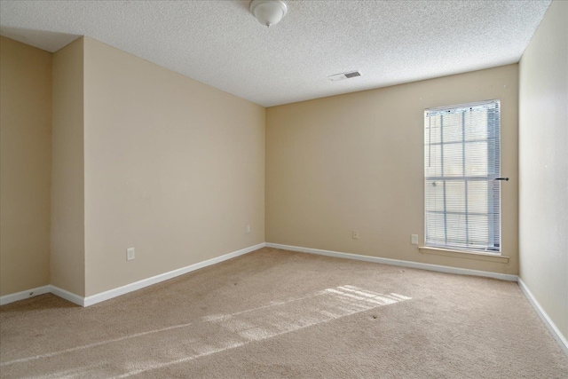 carpeted spare room featuring a textured ceiling