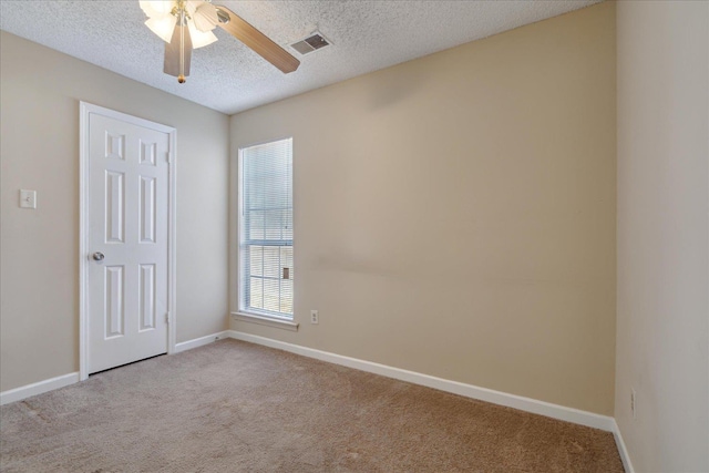 carpeted empty room featuring ceiling fan and a textured ceiling