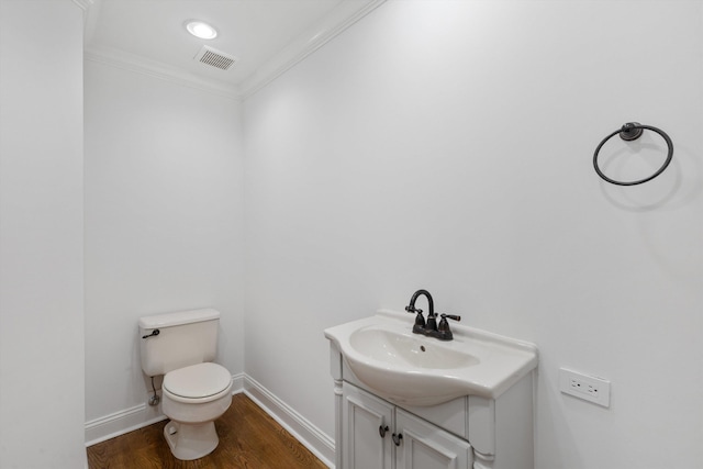 bathroom with hardwood / wood-style floors, vanity, toilet, and ornamental molding