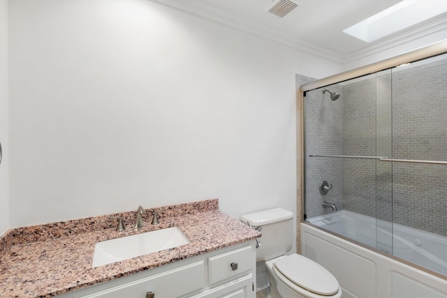 full bathroom featuring vanity, crown molding, a skylight, toilet, and enclosed tub / shower combo