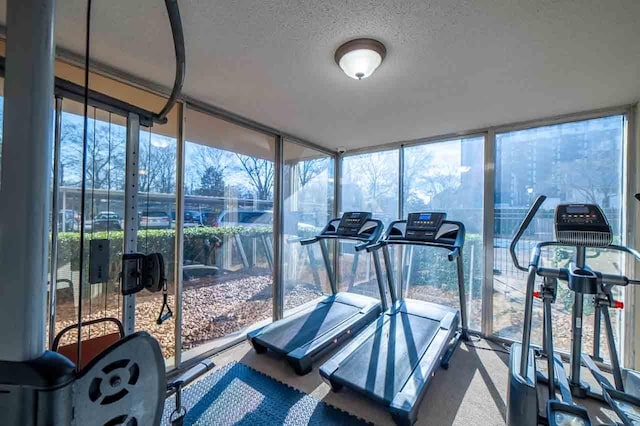 gym featuring a textured ceiling, expansive windows, and plenty of natural light