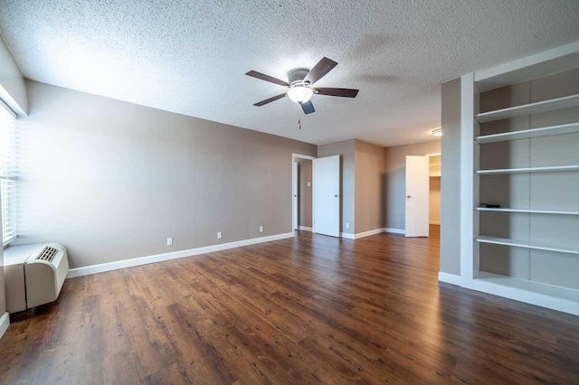 interior space with a textured ceiling, ceiling fan, built in features, and dark hardwood / wood-style floors