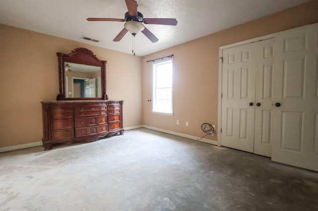 unfurnished bedroom featuring concrete flooring, ceiling fan, and a closet