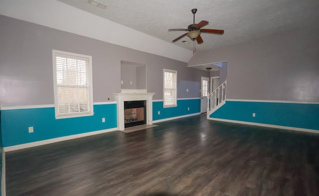 unfurnished living room featuring lofted ceiling, dark wood-type flooring, a wealth of natural light, and ceiling fan